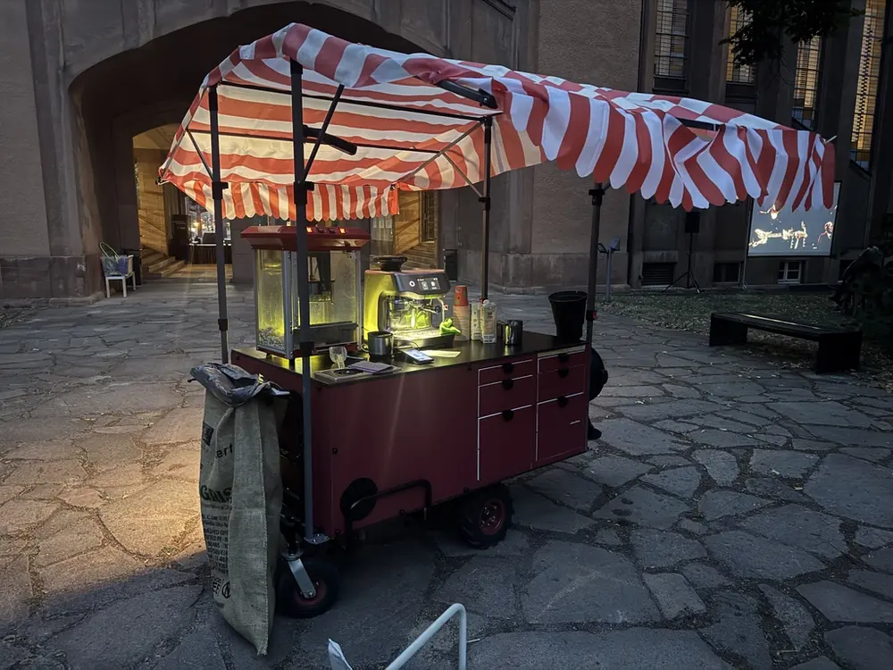 Coffee Train unter dem Torbogen des Grassimuseums mit gestreiftem Sonnendach